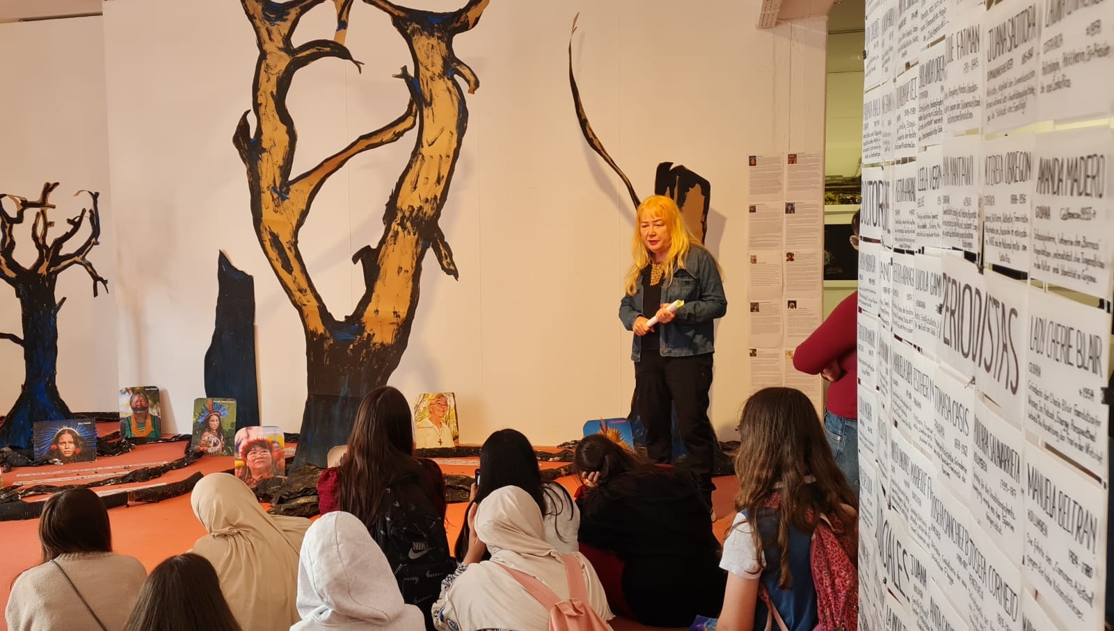 Lucilene Pampolha mit Besucherinnengruppe vor ihrer Installation "Phönixe aus der Asche"